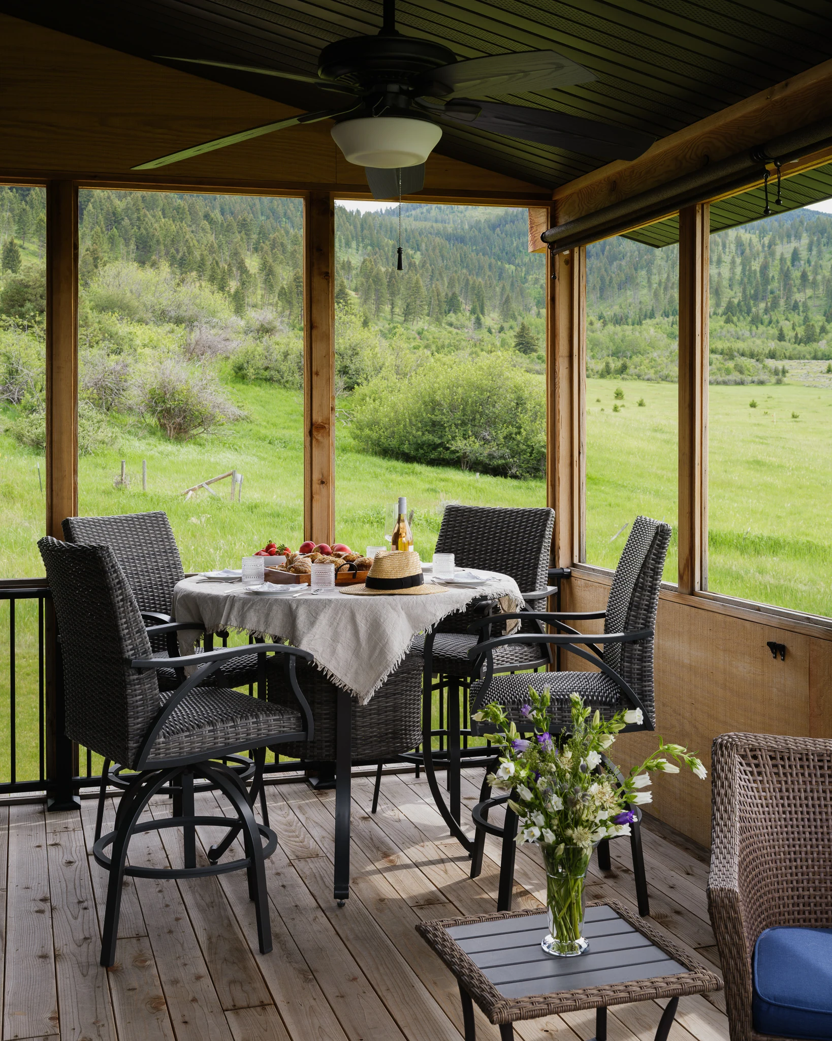 Screened porch with a dining table overlooking the meadow — architectural photography Livingston Montana, Bear Canyon Ranch